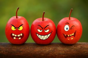 Drei witzige Äpfel auf Baumstamm