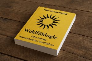 3D-Mock-up des Buches Wohlfühlogie-oder (m)eine Wissenschaft des Wohlfühlens auf einer dunklen Holztisch-Oberfläche