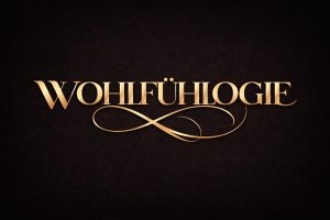 WOHLFÜHLOGIE in goldener Schrift auf dunklem Hintergrund als Titelbild für den Grundlagenartikel zur Wissenschaft des Wohlfühlens