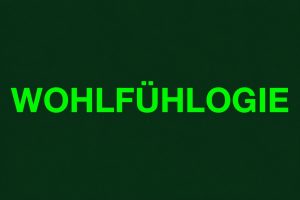 WOHLFÜHLOGIE-Schriftzug in leuchtendem Grün auf dunkelgrünem Hintergrund als Symbol für die beruhigende Wirkung der Farbe Grün, Natur und Wohlbefinden.